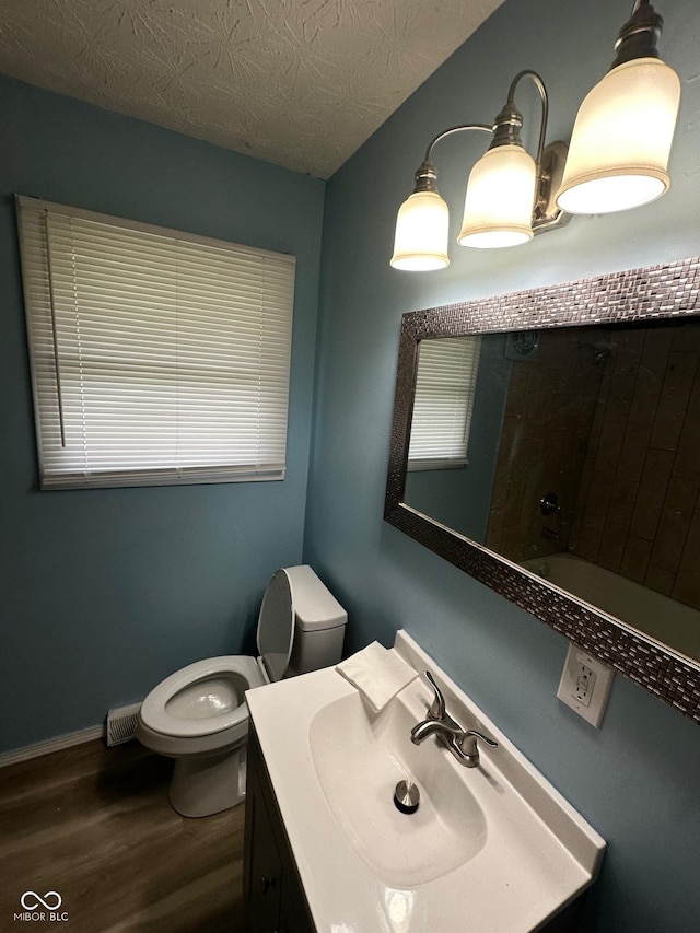 4908 Elmhurst Dr, Indianapolis, IN 46226 - full bath with wood finished floors, vanity, and a textured ceiling