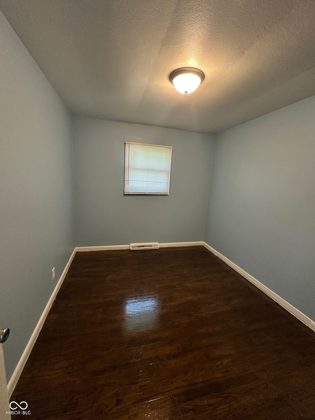 4908 Elmhurst Dr, Indianapolis, IN 46226 - empty room with wood finished floors and a textured ceiling