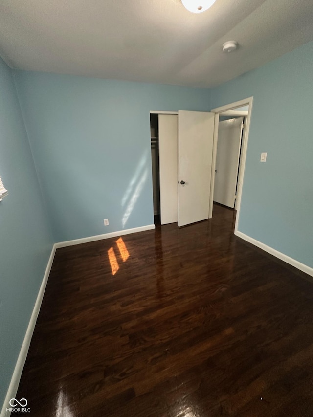 4908 Elmhurst Dr, Indianapolis, IN 46226 - unfurnished bedroom with dark wood-type flooring and a closet