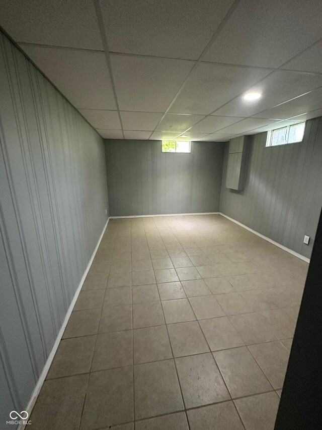 4908 Elmhurst Dr, Indianapolis, IN 46226 - below grade area with a drop ceiling, wooden walls, and tile patterned flooring