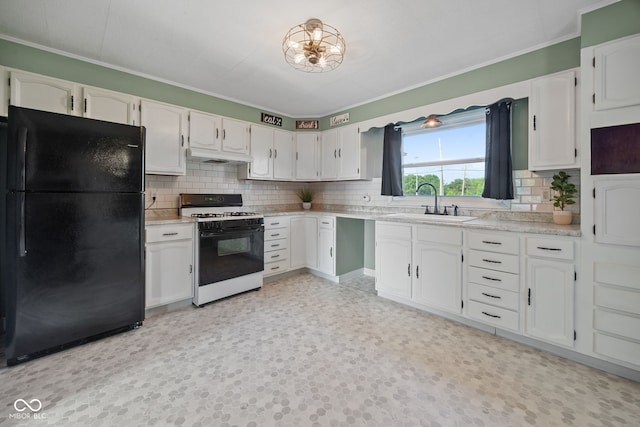 900 N College St N, Veedersburg, IN 47987 - kitchen with freestanding refrigerator, white range with gas cooktop, crown molding, tasteful backsplash, and white cabinets