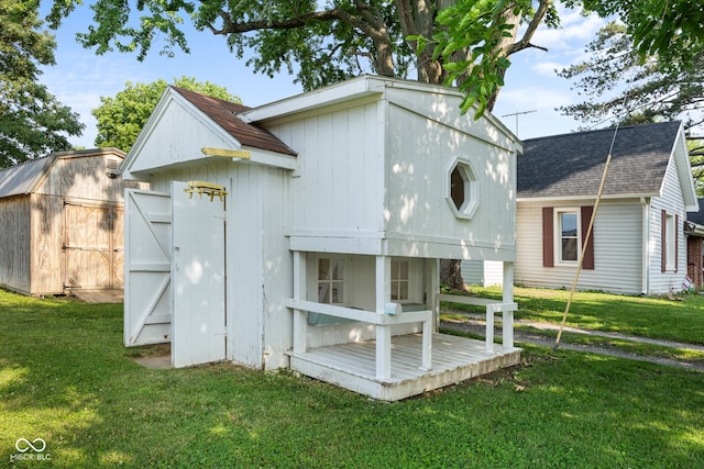 900 N College St N, Veedersburg, IN 47987 - back of house with a shingled roof, a yard, and an outbuilding