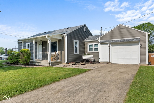 900 N College St N, Veedersburg, IN 47987 - view of front of property featuring a front yard, a garage, driveway, covered porch, and a shingled roof