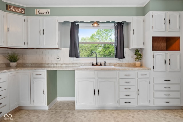 900 N College St N, Veedersburg, IN 47987 - kitchen with white cabinets, backsplash, ornamental molding, and light countertops