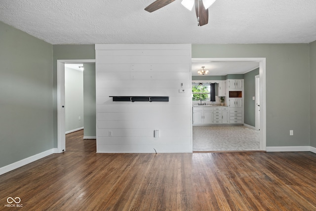 900 N College St N, Veedersburg, IN 47987 - unfurnished living room with dark wood finished floors, a ceiling fan, and a textured ceiling