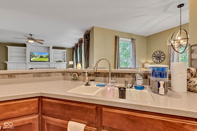 705 Ridge Gate Dr, Brownsburg, IN 46112 - kitchen with brown cabinets, ceiling fan, light countertops, decorative light fixtures, and a chandelier