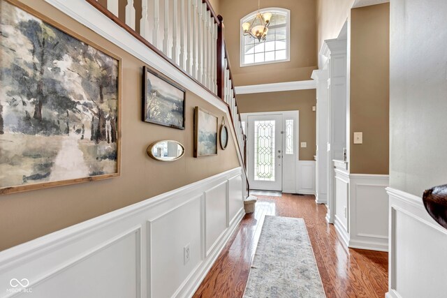 705 Ridge Gate Dr, Brownsburg, IN 46112 - entryway featuring a decorative wall, healthy amount of natural light, wainscoting, a chandelier, and light wood finished floors