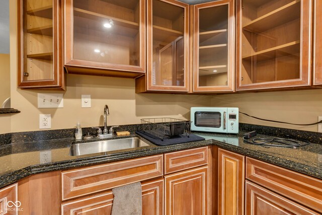 705 Ridge Gate Dr, Brownsburg, IN 46112 - kitchen featuring glass insert cabinets, dark stone countertops, and brown cabinets