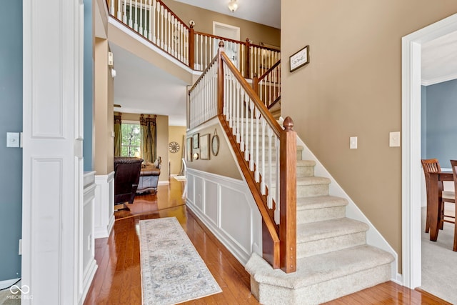 705 Ridge Gate Dr, Brownsburg, IN 46112 - stairway featuring wood finished floors and a wainscoted wall