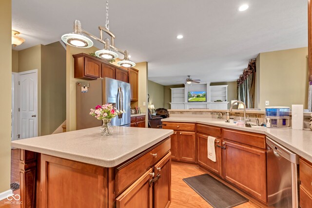 705 Ridge Gate Dr, Brownsburg, IN 46112 - kitchen with stainless steel appliances, a ceiling fan, light countertops, light wood-type flooring, and a kitchen island