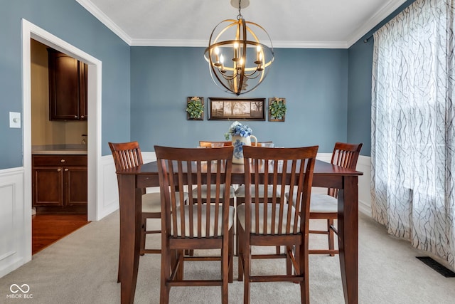 705 Ridge Gate Dr, Brownsburg, IN 46112 - carpeted dining space with a chandelier, ornamental molding, and a wainscoted wall