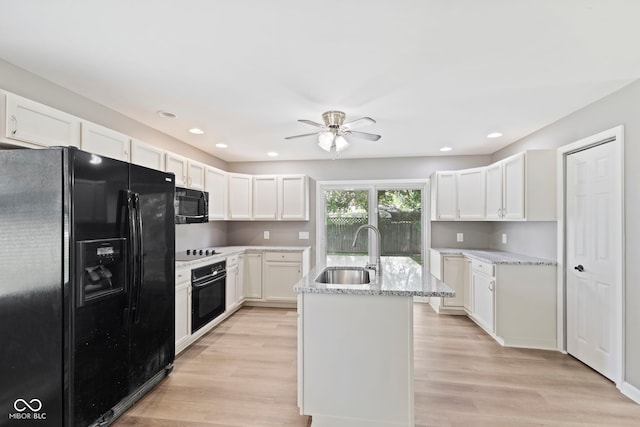 7928 Vontress St, Coatesville, IN 46121 - kitchen featuring black appliances, light stone counters, light wood finished floors, a ceiling fan, and white cabinets