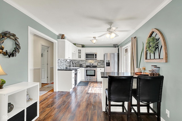 12606 Markay Dr, Fishers, IN 46038 - kitchen featuring stainless steel appliances, tasteful backsplash, glass insert cabinets, dark countertops, and crown molding