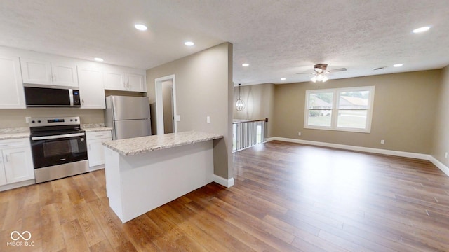 15 Morton Way, Batesville, IN 47006 - kitchen with appliances with stainless steel finishes, white cabinetry, a peninsula, light wood-style flooring, and ceiling fan