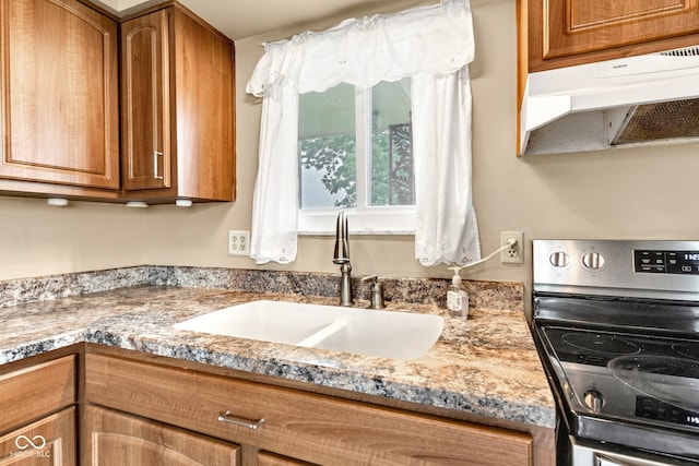 10965 W Base Line Rd, Jamestown, IN 46147 - kitchen with electric range, under cabinet range hood, and brown cabinets