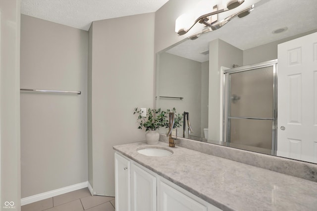9055 Glass Chimney Ln, Fishers, IN 46037 - bathroom with vanity, a stall shower, tile patterned floors, and a textured ceiling