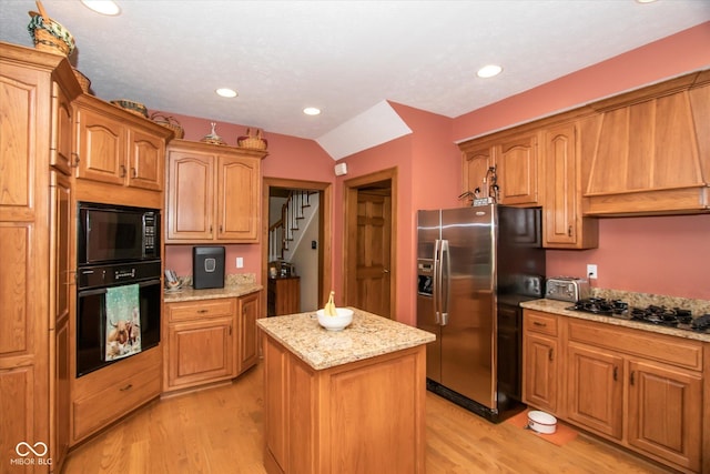 5538 N 700 W, Mccordsville, IN 46055 - kitchen featuring black appliances, light wood-style floors, a center island, light stone countertops, and premium range hood