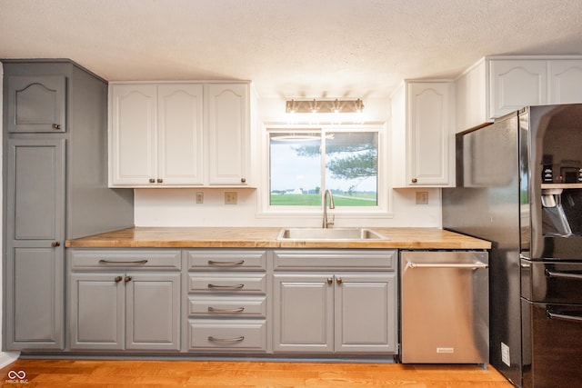4491 W 600 N, Anderson, IN 46011 - kitchen featuring stainless steel appliances, a textured ceiling, gray cabinets, light wood-style floors, and wooden counters
