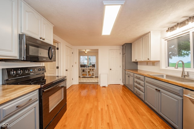 4491 W 600 N, Anderson, IN 46011 - kitchen with black appliances, gray cabinetry, white cabinets, light wood-type flooring, and a textured ceiling