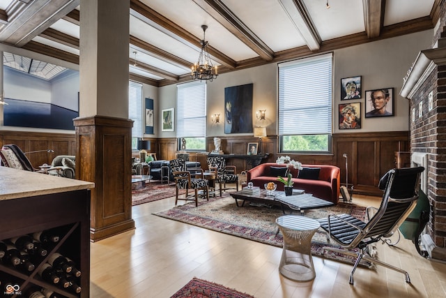 3959 Central Ave, Indianapolis, IN 46205 - living room featuring a wainscoted wall, beamed ceiling, wood finished floors, a chandelier, and a fireplace