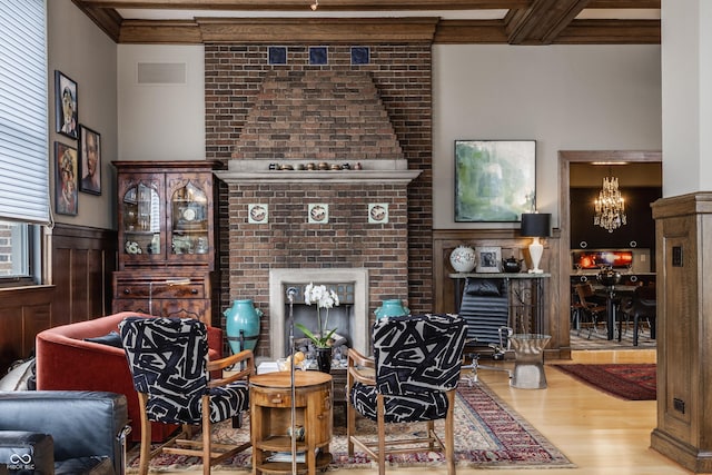3959 Central Ave, Indianapolis, IN 46205 - living room featuring wood finished floors, a fireplace, a chandelier, wainscoting, and crown molding
