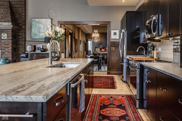 3959 Central Ave, Indianapolis, IN 46205 - kitchen with stainless steel appliances, a chandelier, light stone counters, and backsplash
