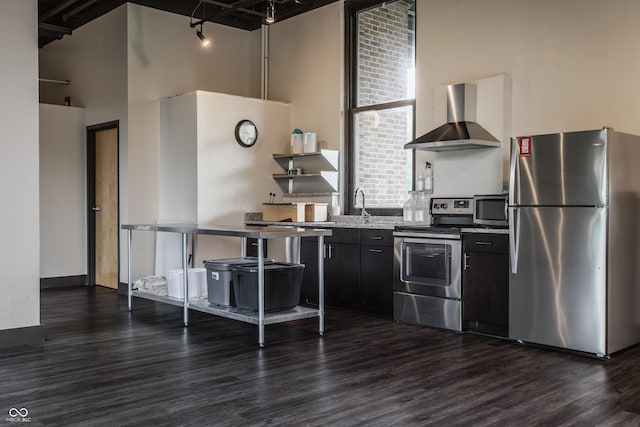 3959 Central Ave, Indianapolis, IN 46205 - kitchen featuring appliances with stainless steel finishes, wall chimney range hood, dark wood finished floors, a high ceiling, and dark cabinets