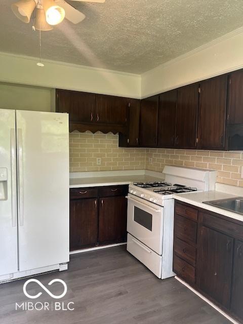 5312 N Kercheval Dr, Indianapolis, IN 46226 - kitchen with white appliances, a textured ceiling, light countertops, dark brown cabinetry, and dark wood-style flooring