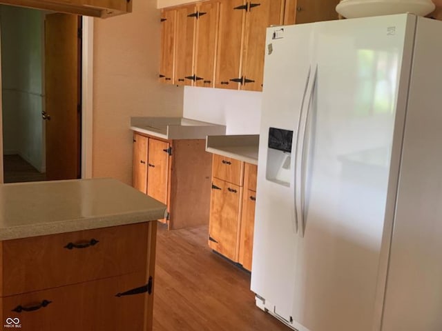 24 David Dr, North Vernon, IN 47265 - kitchen featuring white fridge with ice dispenser, light wood-type flooring, light countertops, and brown cabinets
