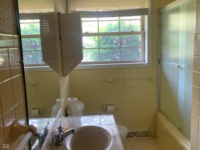 24 David Dr, North Vernon, IN 47265 - bathroom with vanity, tile walls, and bath / shower combo with glass door