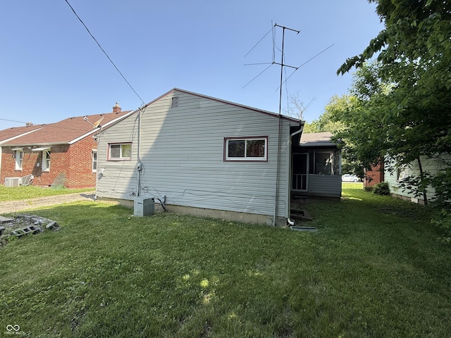 1227 W 9th St, Anderson, IN 46016 - view of side of home with a lawn and a cooling unit