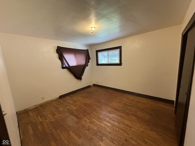 1227 W 9th St, Anderson, IN 46016 - empty room featuring dark wood-style flooring and baseboards