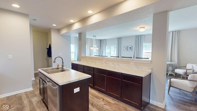 16551 Branham Dr, Fishers, IN 46040 - kitchen with light wood-style floors, dark brown cabinetry, dishwasher, an island with sink, and recessed lighting