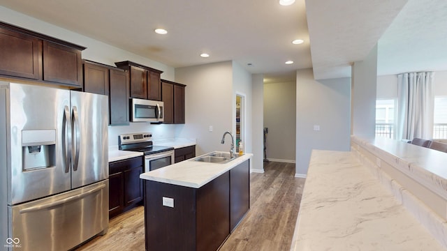 16551 Branham Dr, Fishers, IN 46040 - kitchen featuring stainless steel appliances, recessed lighting, a center island with sink, dark brown cabinetry, and light wood-style floors