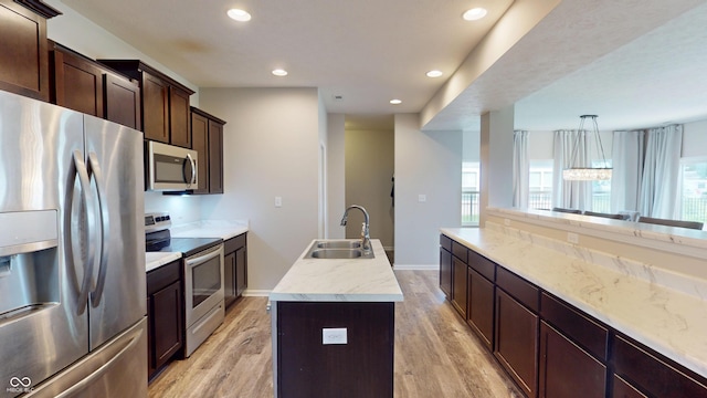 16551 Branham Dr, Fishers, IN 46040 - kitchen with stainless steel appliances, a kitchen island with sink, light wood-style flooring, recessed lighting, and dark brown cabinetry