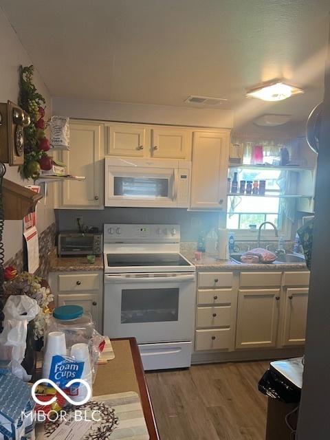 2021 Columbia Ave, Indianapolis, IN 46202 - kitchen with white appliances, white cabinetry, and wood finished floors