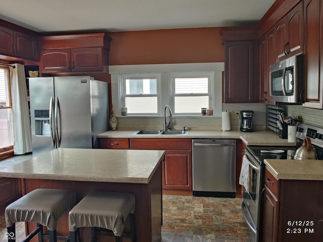 121 N Main St, Pendleton, IN 46064 - kitchen featuring stainless steel appliances, light countertops, decorative backsplash, and a kitchen bar