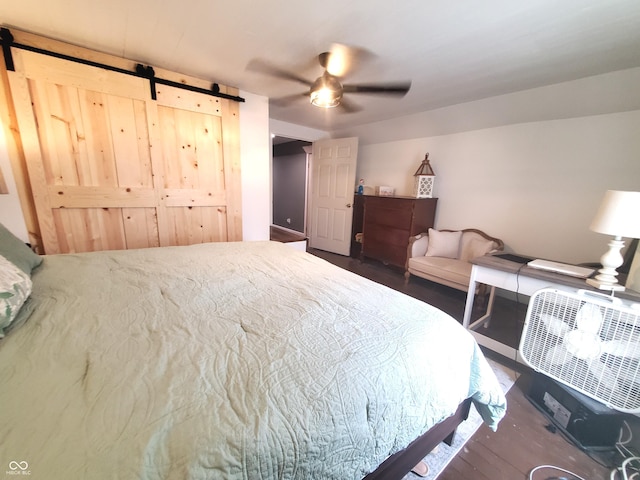 702 W Cross St, Brownstown, IN 47220 - bedroom with a barn door, wood finished floors, and ceiling fan