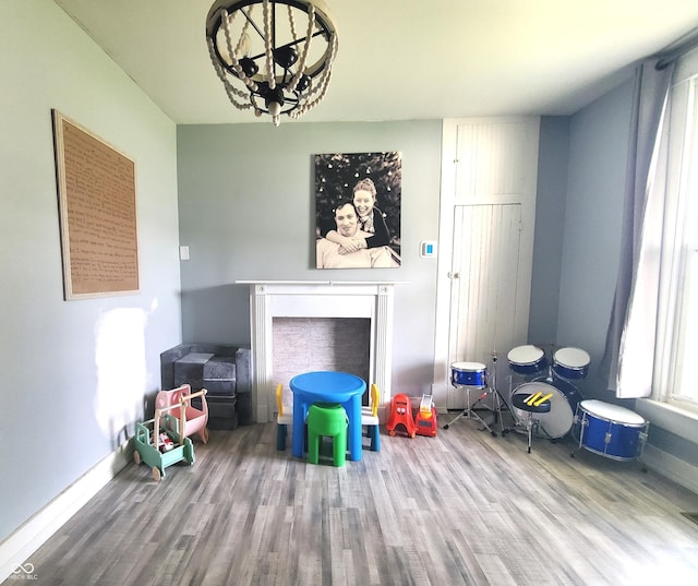 702 W Cross St, Brownstown, IN 47220 - unfurnished living room featuring wood finished floors, a chandelier, and a fireplace
