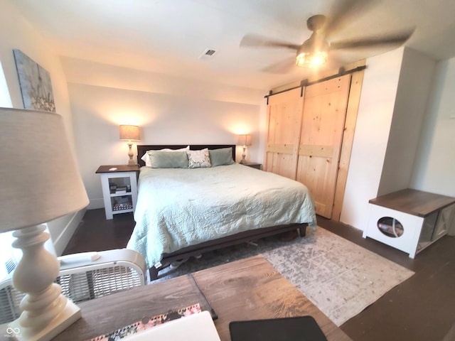702 W Cross St, Brownstown, IN 47220 - bedroom with a barn door, wood finished floors, and ceiling fan