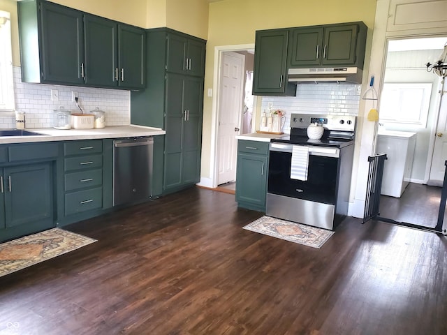 702 W Cross St, Brownstown, IN 47220 - kitchen with appliances with stainless steel finishes, under cabinet range hood, light countertops, tasteful backsplash, and dark wood finished floors