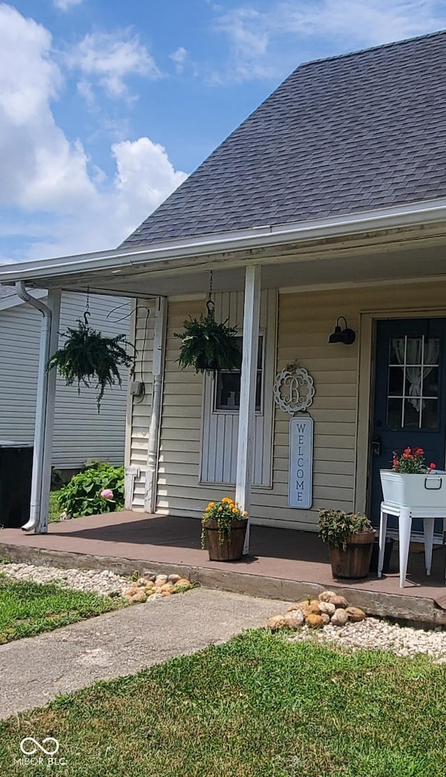 702 W Cross St, Brownstown, IN 47220 - doorway to property featuring roof with shingles and a porch