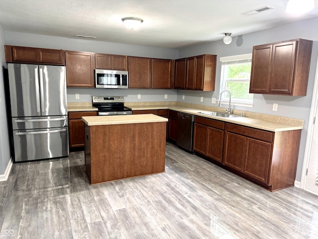 3314 Montgomery Dr, Indianapolis, IN 46227 - kitchen featuring stainless steel appliances, light countertops, light wood-type flooring, and a center island