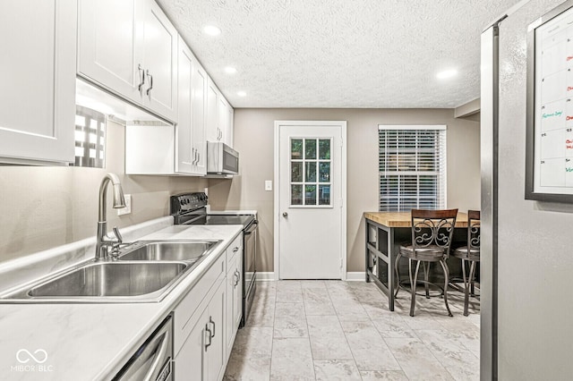 7616 Concord Ln, Fishers, IN 46038 - kitchen with appliances with stainless steel finishes, light countertops, white cabinetry, recessed lighting, and a textured ceiling