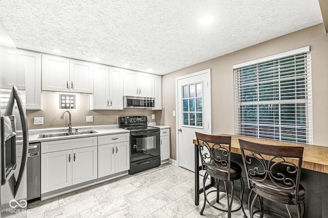 7616 Concord Ln, Fishers, IN 46038 - kitchen featuring stainless steel appliances, light countertops, a textured ceiling, recessed lighting, and white cabinetry