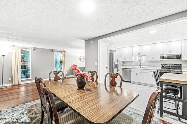 7616 Concord Ln, Fishers, IN 46038 - dining area featuring a textured ceiling and light wood-type flooring