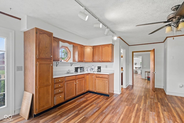 925 W Hancock Rd, Scottsburg, IN 47170 - kitchen with ceiling fan, light countertops, wood finished floors, a textured ceiling, and brown cabinets