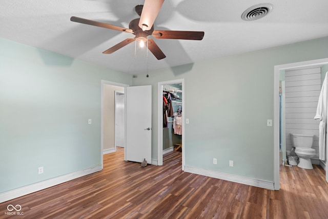 925 W Hancock Rd, Scottsburg, IN 47170 - unfurnished bedroom with wood finished floors, a spacious closet, a closet, a ceiling fan, and ensuite bath