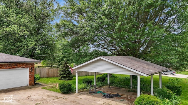 925 W Hancock Rd, Scottsburg, IN 47170 - view of patio featuring a garage, concrete driveway, and view of scattered trees