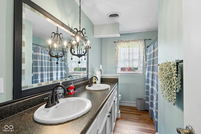 925 W Hancock Rd, Scottsburg, IN 47170 - bathroom with double vanity, wood finished floors, a chandelier, a textured ceiling, and a shower with shower curtain
